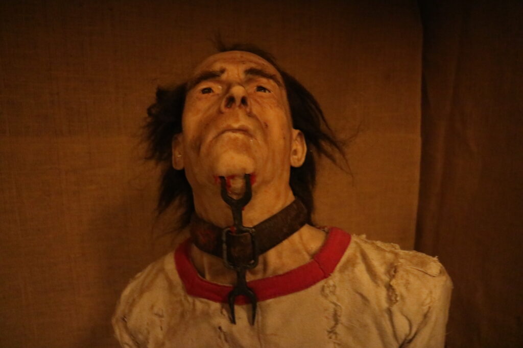 a lifelike depiction of a medieval torture victim with a torture device called the "heretic's fork."