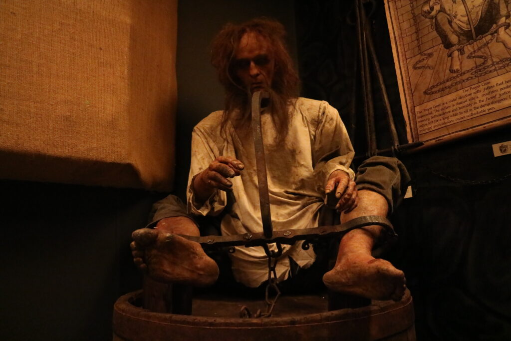 a life-size figure of a medieval person in a torture setting.